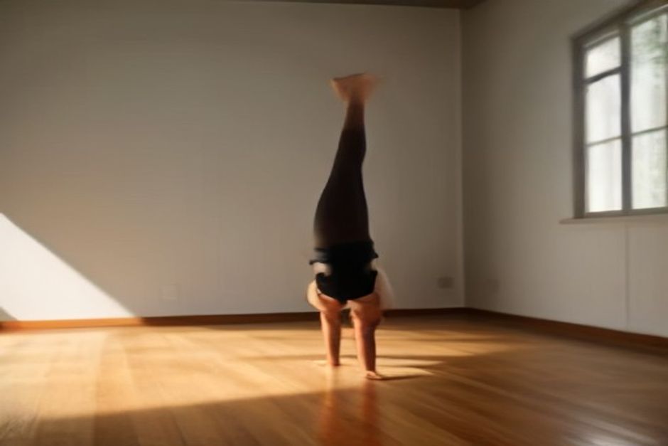 Bare feet on a wooden yoga studio floor in soft natural light, one foot flexed