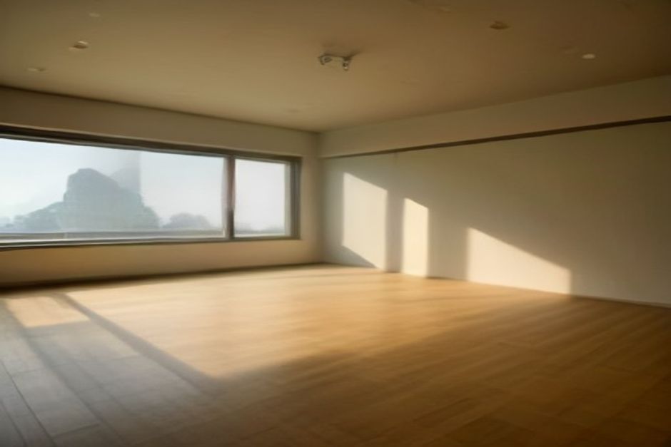 A calm yoga studio with mats spaced on a wooden floor, a few blocks and folded blankets at the wall, soft natural light