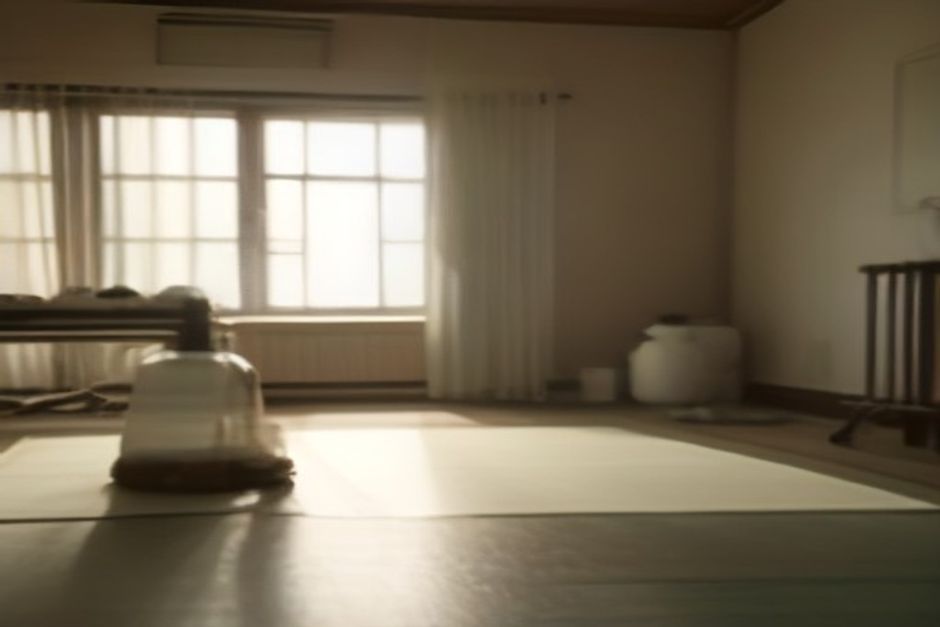 A yoga mat with a towel and a large water bottle in a warm, steamy studio, soft golden light