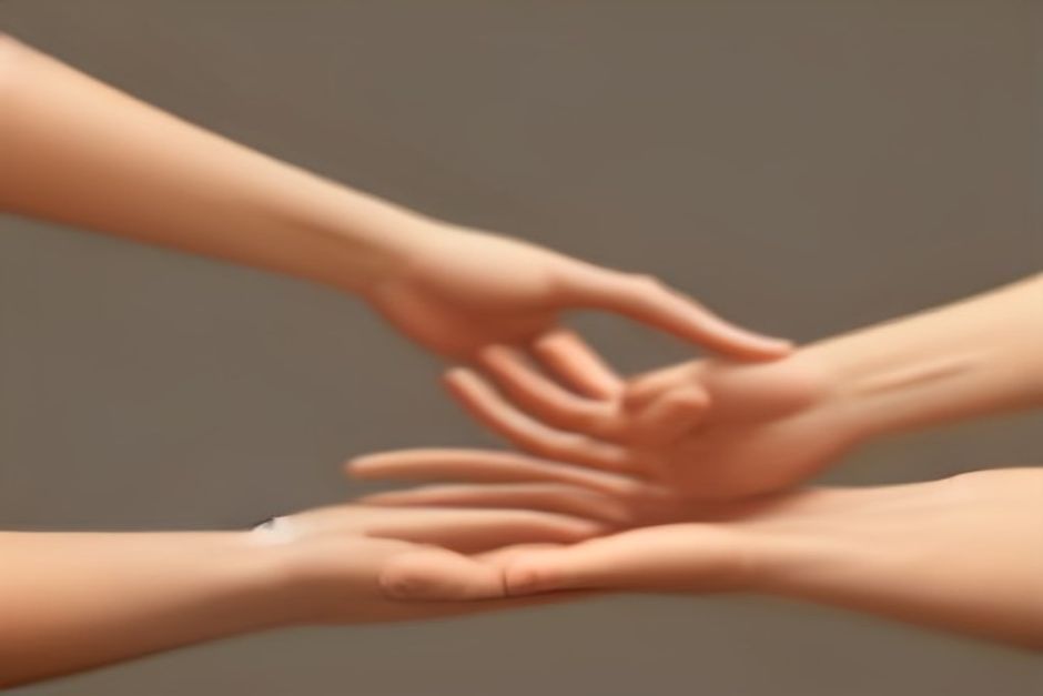 Hands pressed together at the chest in a simple greeting gesture, warm earth tones